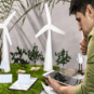 Side View Man Using tablet eco friendly wind power project layout